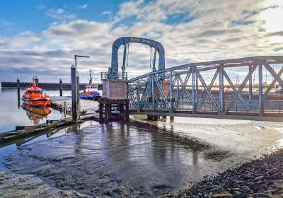 Nassaubrücke bei Niedrigwasser. Der Schwimmponton liegt sehr niedrig, die Brücke neigt sich abwärts in Richtung Meer.