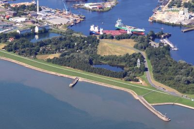 Luftbildaufnahme der Schleuseninsel. Am unteren Bildrand das Meer, in das die beiden Molen der ehemaligen 3. Einfahrt ragen. Am oberen Bildrand ist das tiefblaue Wasser des inneren Hafens zu erkennen.