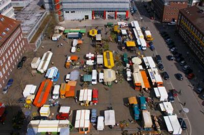 Der Rathausplatz vom Rathausturm aufgenommen. Im Hintergrund das Ratrium. Auf dem Platz zahlreiche Marktstände.