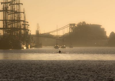 Großsegler liegen morgens zur Goldenen Stunde am Bontekai. Im Hintergrund die KW-Brücke, davor die Konturen von Kajakfahrern.