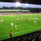 Jadestadion Ein Fußballspiel unter Flutlicht im Jadestadion. Im Vordergrund sind die Köpfe der Zuschauer auf der vollbesetzten Tribüne zu sehen.